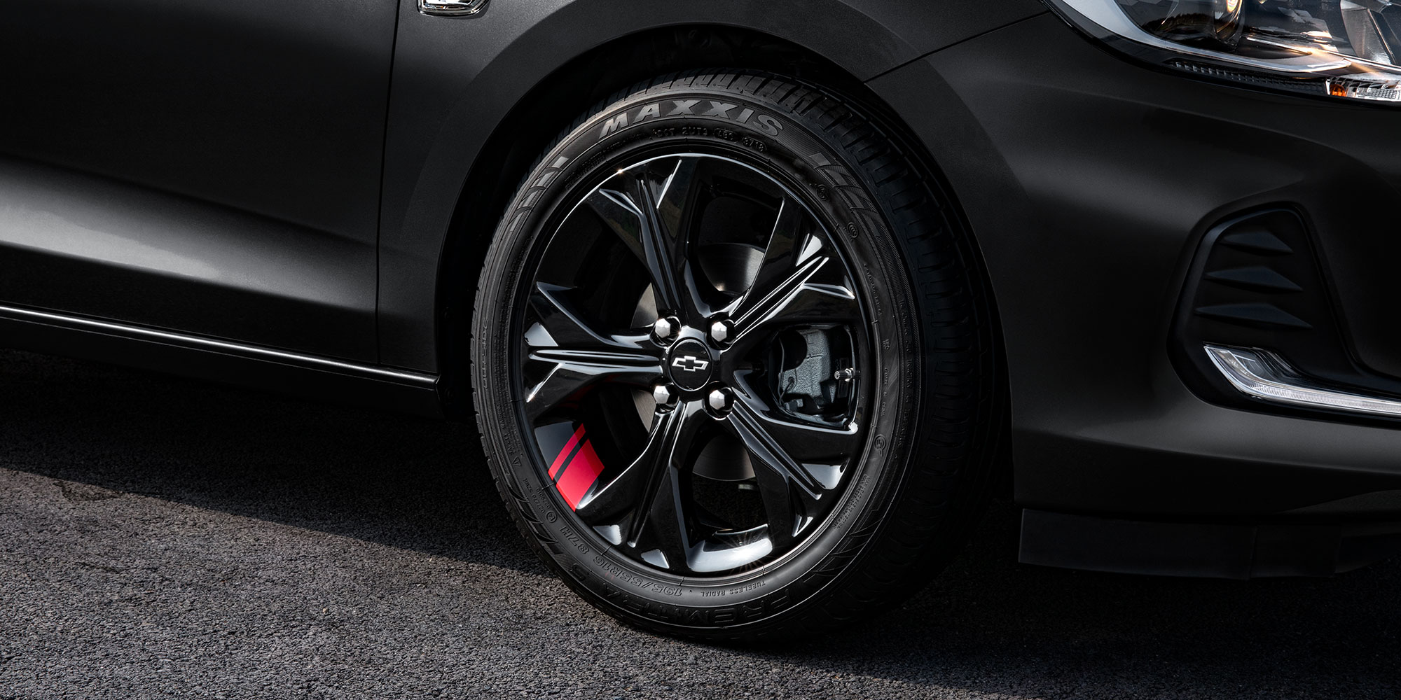 Chevrolet Onix 2025 versión Redline, sedán deportivo con detalles en rojo en sus rines de 16 pulgadas